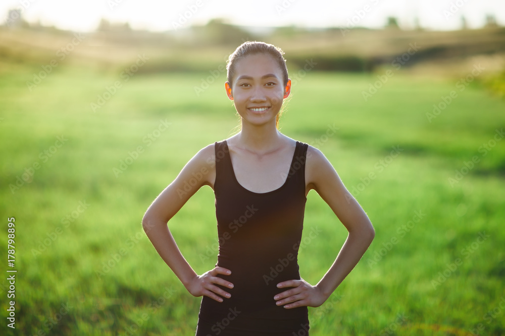 Asian woman standing in sports clothes in field Asian woman standing in sports clothes in field