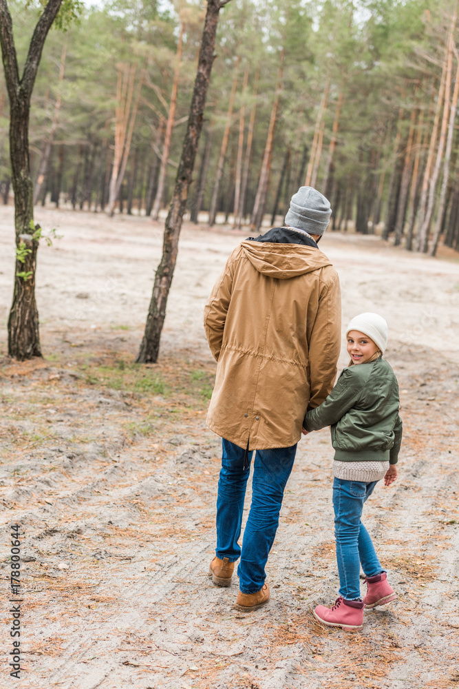 father and daughter walking by forest father and daughter walking by forest