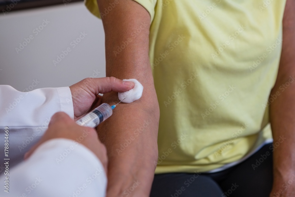 Fototapeta premium Physiotherapist injecting senior patient