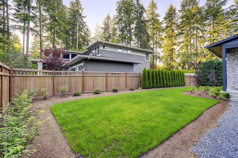 New modern home features a backyard with beautiful garden.