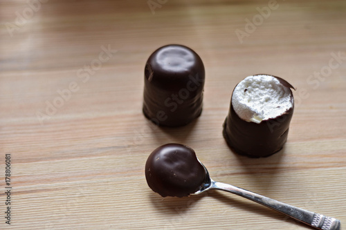 Chocolate mursh-mallow (munchmallow) whit silver spoon at wooden background photo