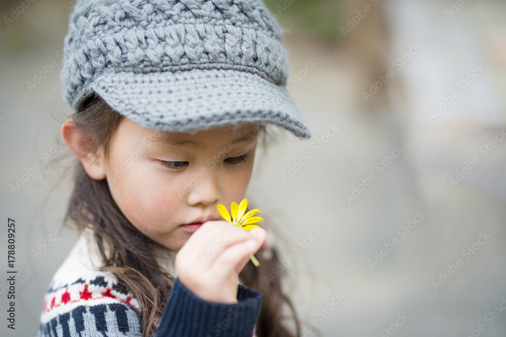 Little girl staring at the yellow flower Little girl staring at the yellow flower
