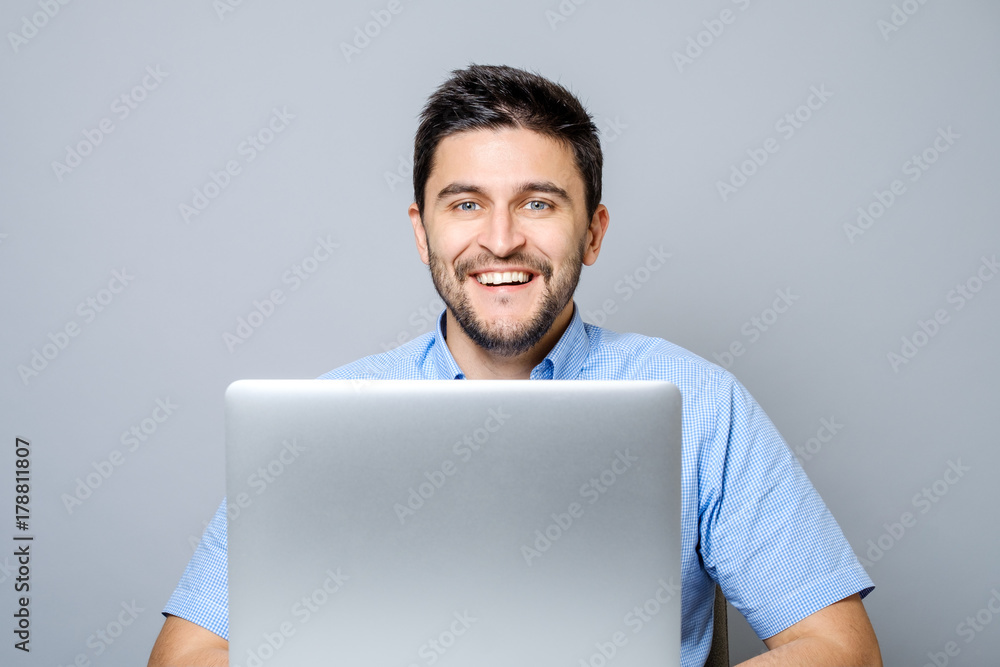 Happy man with laptop computer isolated on gray Happy man with laptop computer isolated on gray