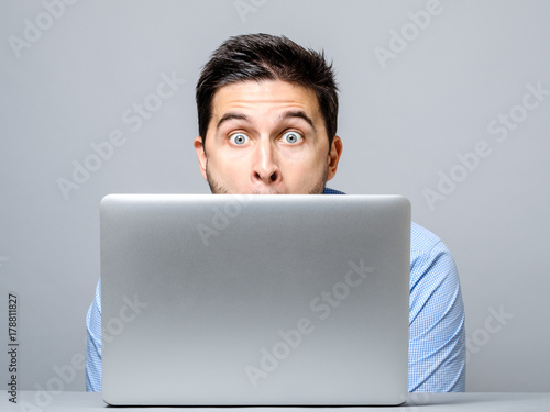 Portrait of amazed man with laptop computer photo