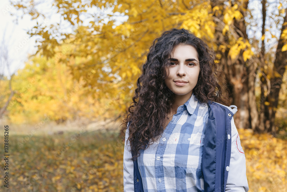 Pretty mixed race woman posing at camera in autumn park. Portrait. Autumn. Outdoor. Pretty mixed race woman posing at camera in autumn park. Portrait. Autumn. Outdoor.
