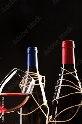 Wineglass and two winebottles photo