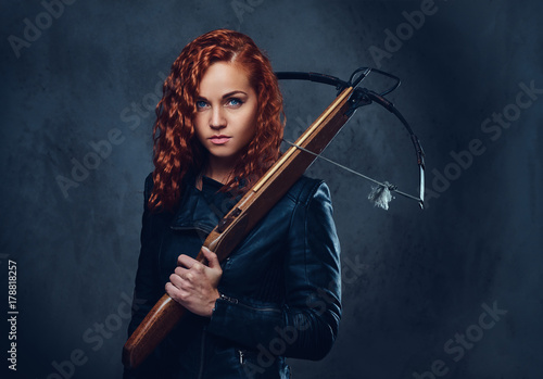 Redhead female  holds crossbow.