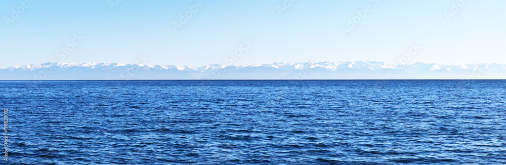 Panoramic view of Lake Baikal and snow-covered mountains on the opposite east coast. Water background