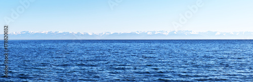 Panoramic view of Lake Baikal and snow-covered mountains on the opposite east coast. Water background