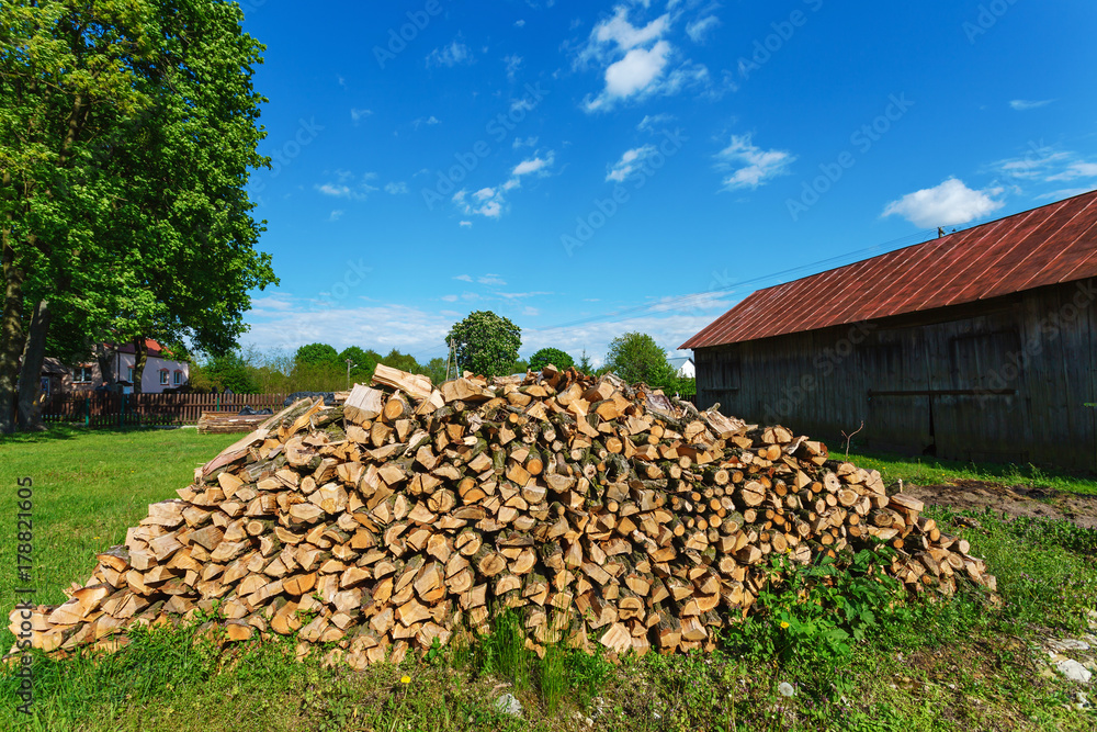 A heap of chopped wood under blue sky, stock for heavy winter
