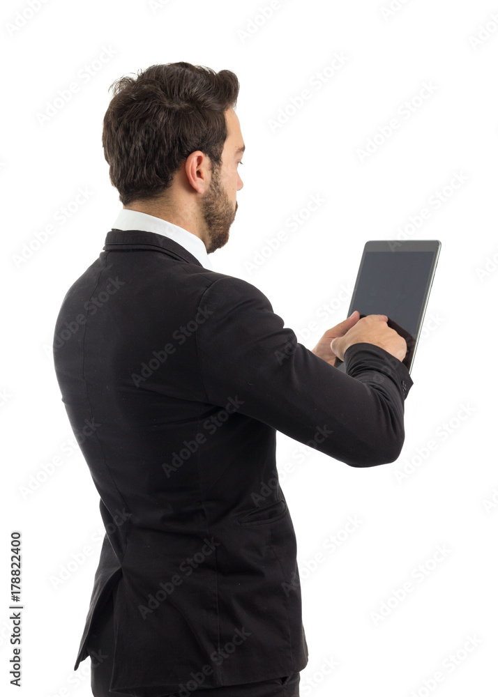 Entrepreneur on the back using a tablet. Beautiful and elegant person is wearing black suit.. Entrepreneur on the back using a tablet. Beautiful and elegant person is wearing black suit..