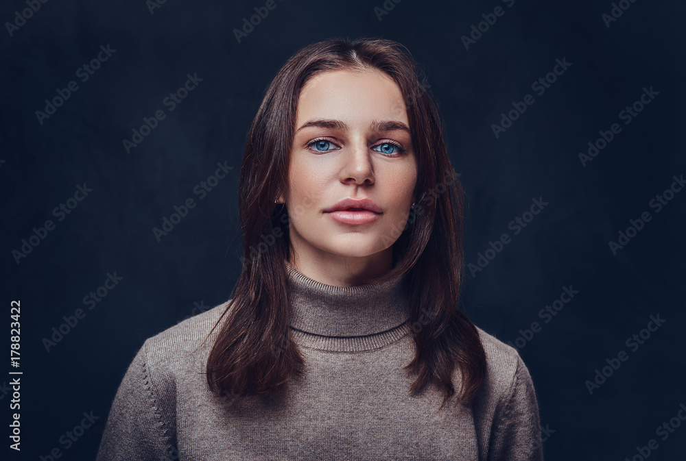 Fototapeta premium A woman dressed in a long neck brown jacket.