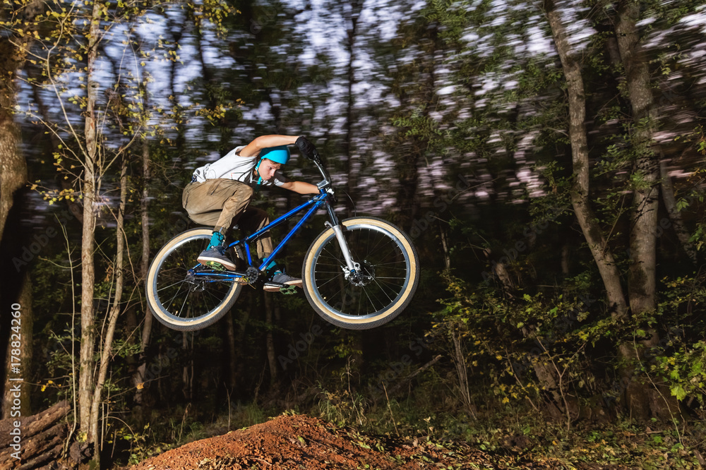 a young guy in a helmet flies on a bicycle after jumping from a kicker a young guy in a helmet flies on a bicycle after jumping from a kicker
