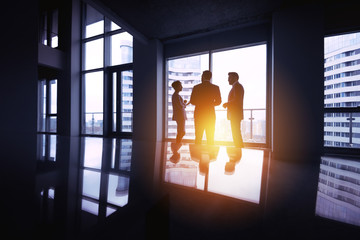 Group businessmen silhouettes three office big window concept
