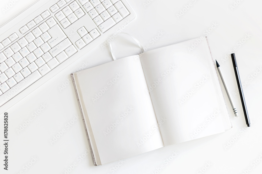 Top view on white table with keyboard, copybook with blank pages and pen with pencil. Flat lay. Top view on white table with keyboard, copybook with blank pages and pen with pencil. Flat lay.
