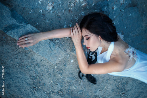 Fallen Angel. A girl with torn off wings, desperately wanders on the ground with hope in her eyes. Artistic Photography