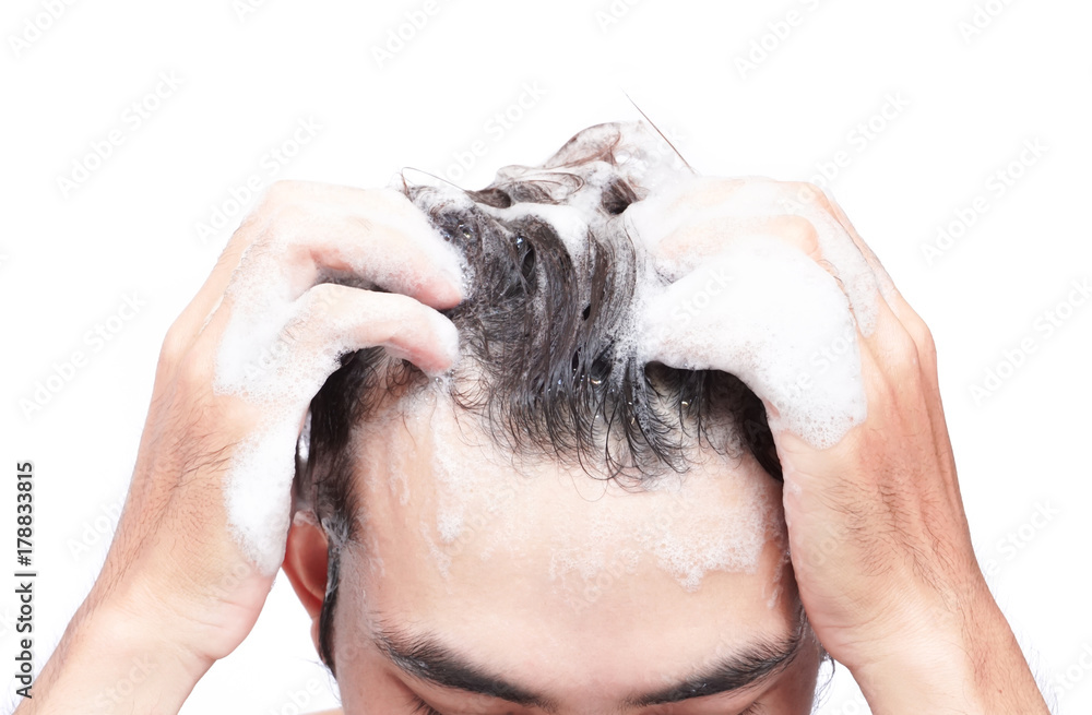 Naklejka premium Closeup young man washing hair with white background, health care concept