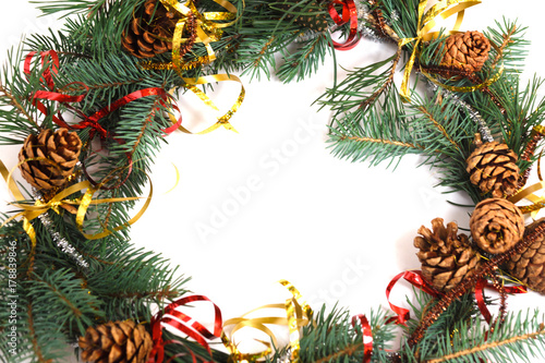 wreath of fir branches with cones stands on white background  near Christmas toys  isolate