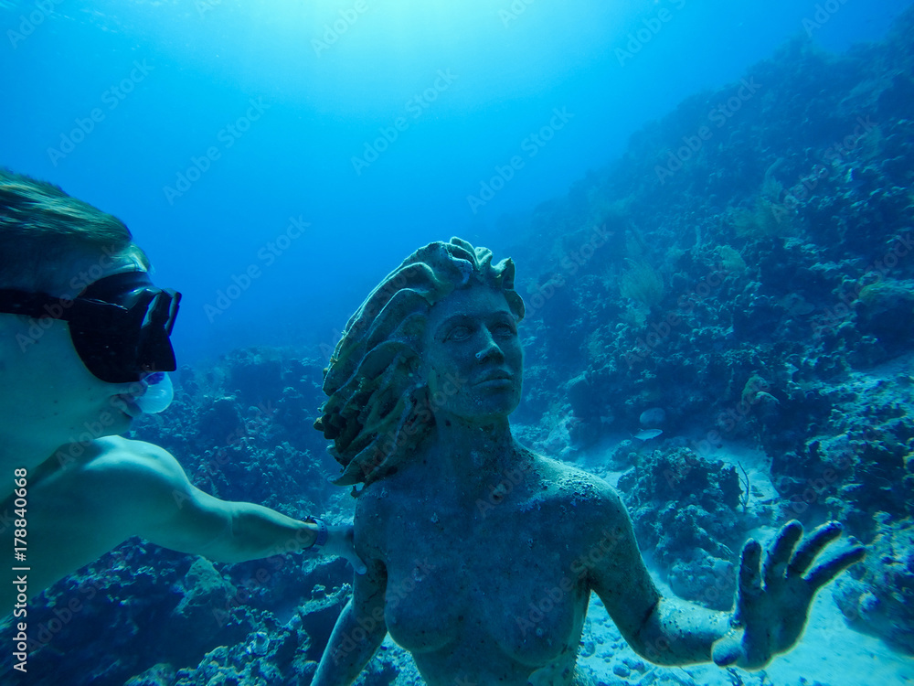 Underwater wide angle selfie of muscular freediver with the mermaid