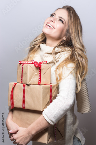 Young beautiful woman holding gifts. Happy girl holding gifts on white background. New Year. Christmas. Birthday.