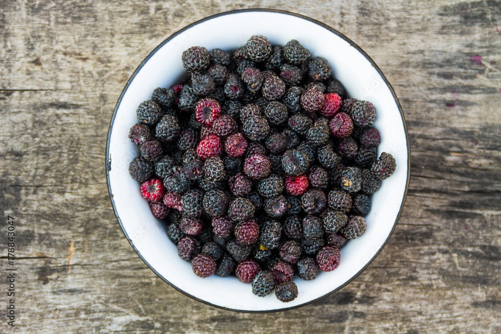 Ripe blackberries in rustic bowl on old wooden background. Top view Ripe blackberries in rustic bowl on old wooden background. Top view