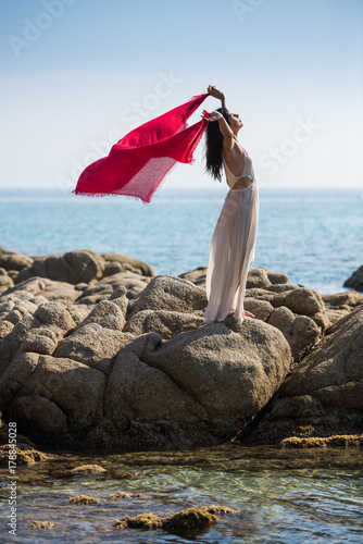 Woman Stretching Arms to Sky at Ocean, Relaxing with Freedom