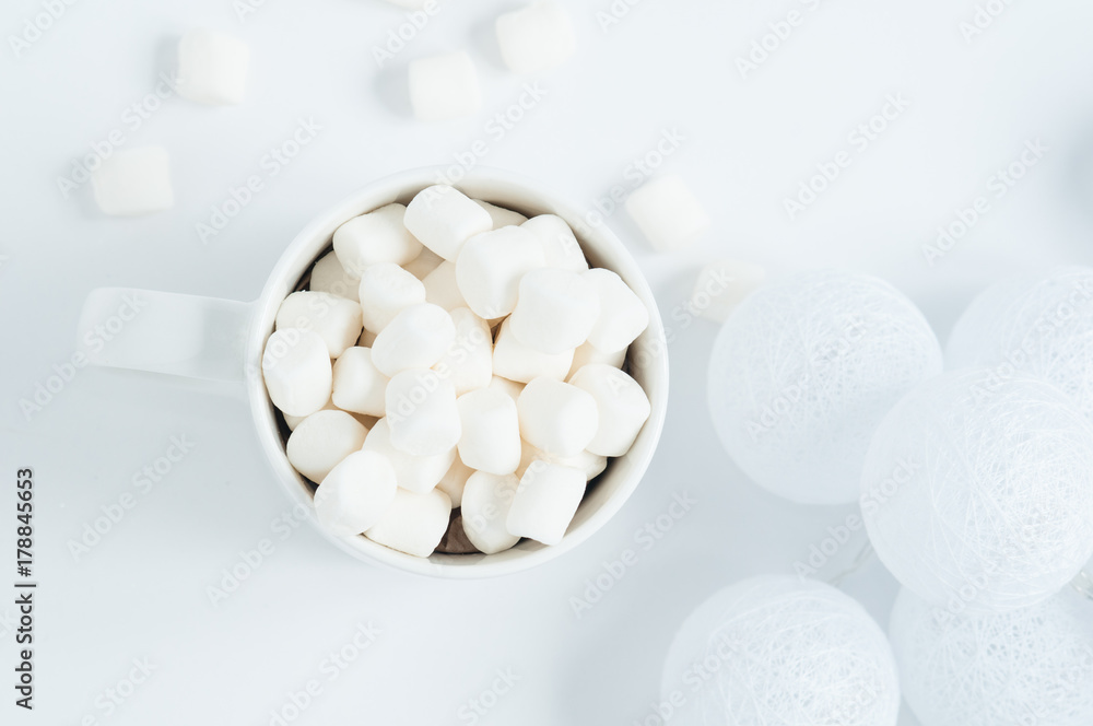 white mug with marshmallows in a winter scene white mug with marshmallows in a winter scene
