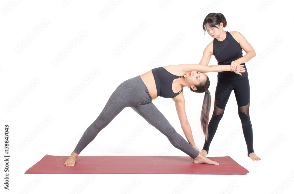 asian woman doing yoga training in Triangle pose on the mat with trainer, teacher assists to make yoga pose isolated on white background, exercise fitness, sport training and healthy lifestyle concept asian woman doing yoga training in Triangle pose on the mat with trainer, teacher assists to make yoga pose isolated on white background, exercise fitness, sport training and healthy lifestyle concept