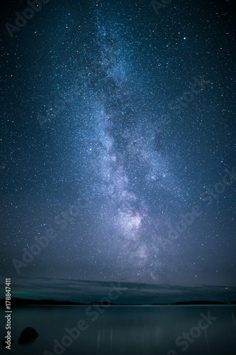 Stars and milky way over sea with reflections