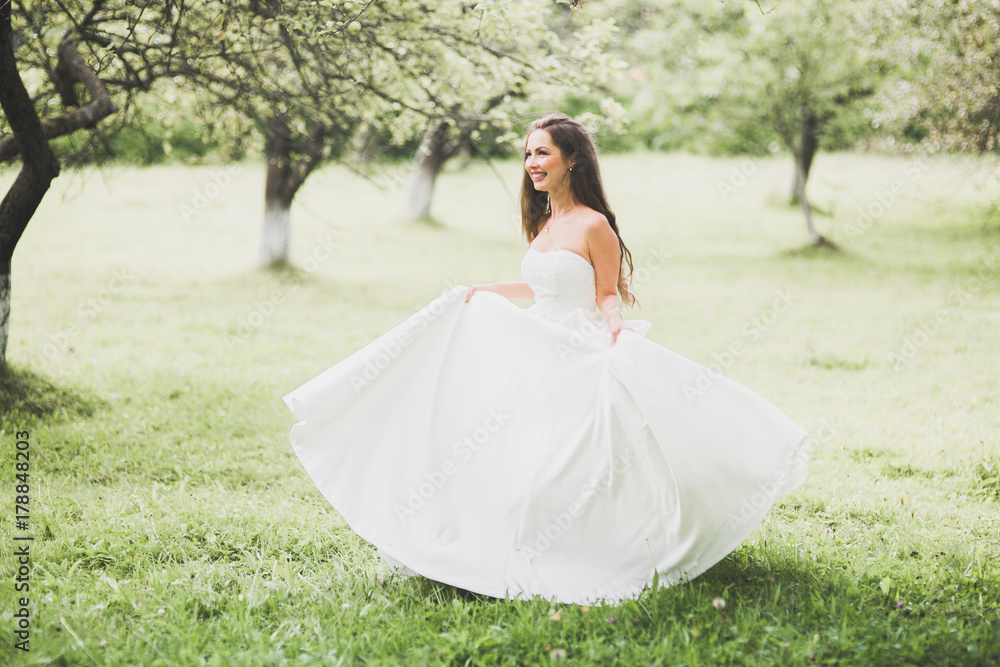 Beautiful bride spinning with perfect dress in the park Beautiful bride spinning with perfect dress in the park