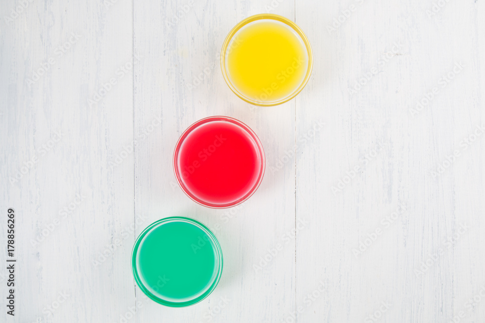 colored liquid on a white wooden background colored liquid on a white wooden background