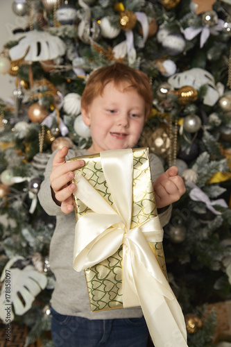 Redhead boy holding a Christmas gift