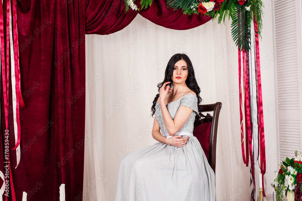Fototapeta premium young woman in elegant blue gray evening dress indoors with beautiful interior