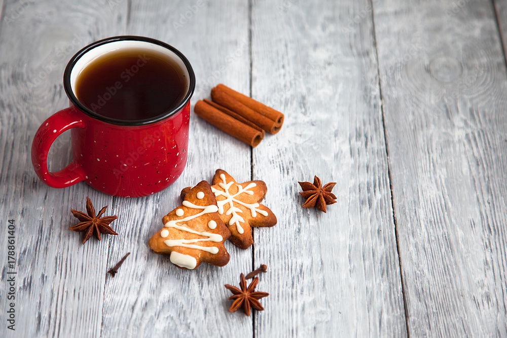 Red cup of tea and Christmas cookies on wooden grey background Red cup of tea and Christmas cookies on wooden grey background