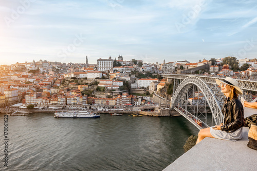 Young woman tourist enjoying great view on the old town and river in Porto city during the sunset in Portugal