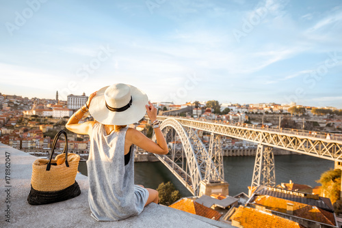 Canvas Print Young woman tourist enjoying beautiful landscape view on the old town with river