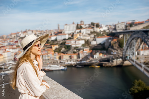 Young woman tourist enjoying beautiful cityscape background with famous bridge in Porto city, Portugal © rh2010