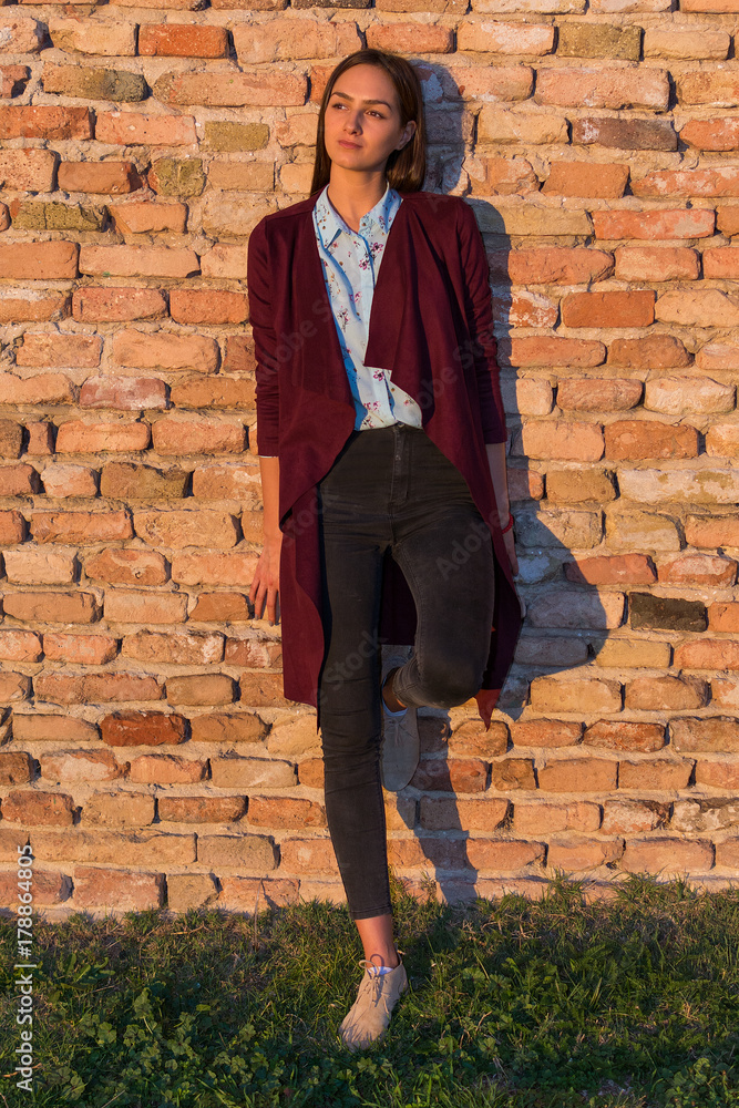 a beautiful girl poses in front of a medieval fortress at sunset a beautiful girl poses in front of a medieval fortress at sunset