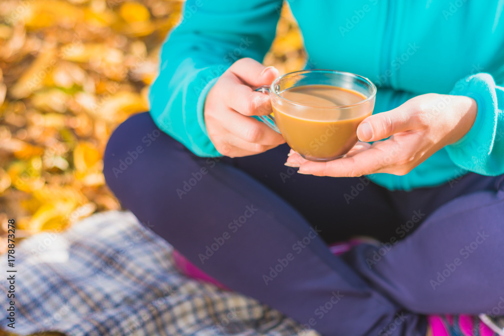 Woman with cup of coffee sitting on a plaid Woman with cup of coffee sitting on a plaid