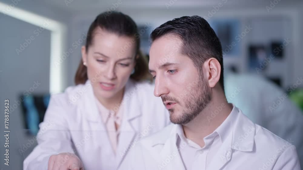 Scientists in lab holding piece of clear material and using as interactive touch screen. Futuristic laboratory, science and research concept. Scientists in lab holding piece of clear material and using as interactive touch screen. Futuristic laboratory, science and research concept.
