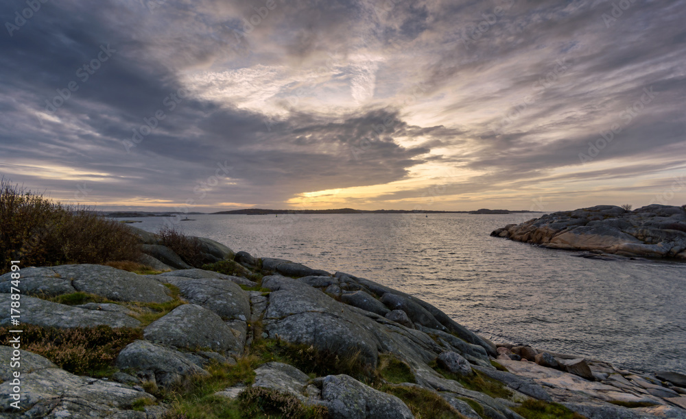 setting sun amid cliffs as seen at salthholmen Gothenburg setting sun amid cliffs as seen at salthholmen Gothenburg