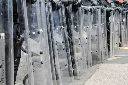Police in riot gear and shields form a line to prevent protesters proceeding. photo