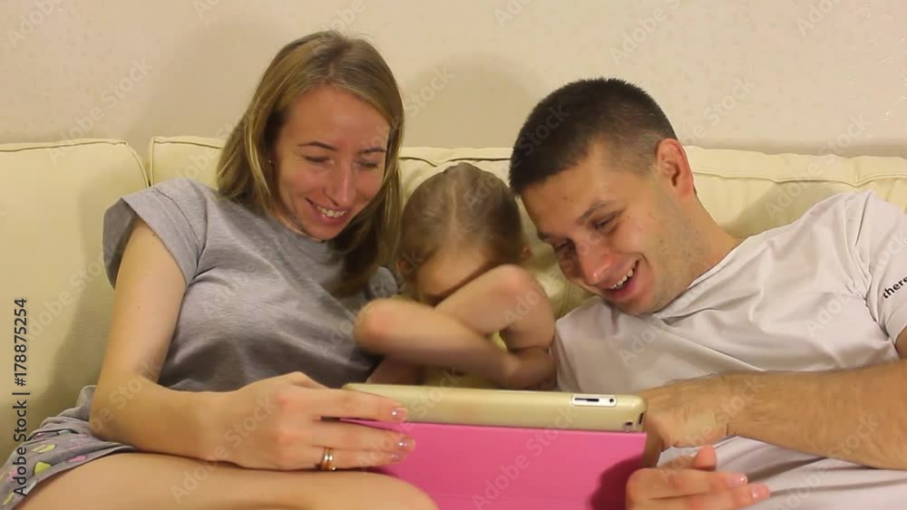 Young Caucasian Family of Three Watching Funny Video on Cellphone Together Young Caucasian Family of Three Watching Funny Video on Cellphone Together