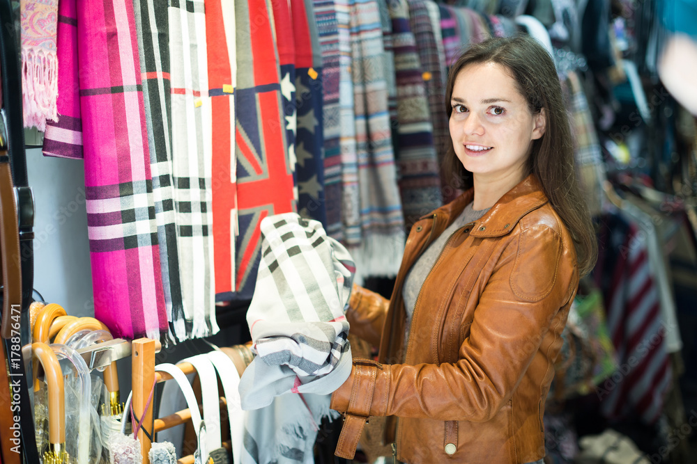 Woman choosing scarf in shop