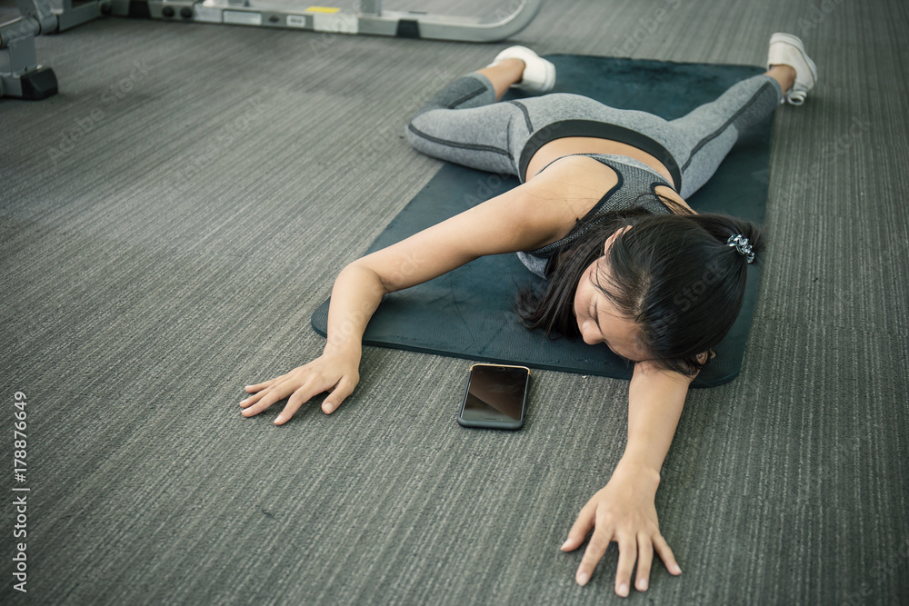 Asian tan woman fainting to the floor during her exercise at the sport