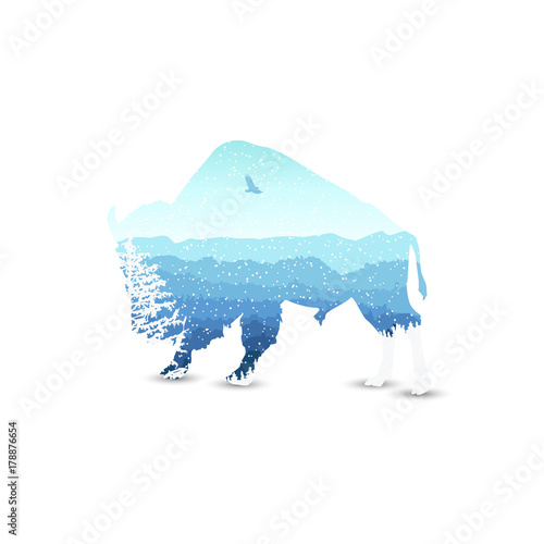 Silhouette of bizon with mountains  landscape and coniferous trees. Blue shades. Winter. Cold. Snowing.
