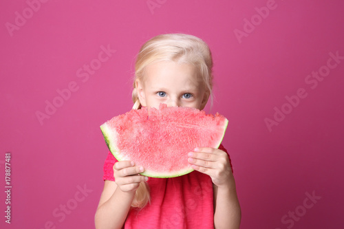 Cute girl eating watermelon on color background