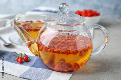 Teapot with goji tea on table