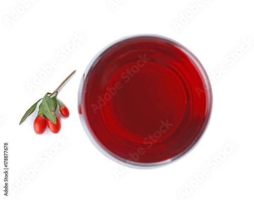 Glass with goji juice on white background