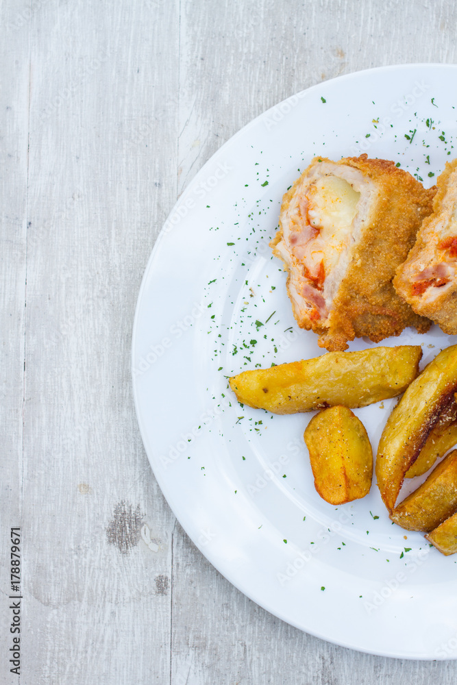 baked potato and slice of veal or other light meat, coated in breadcrumbs and fried baked potato and slice of veal or other light meat, coated in breadcrumbs and fried